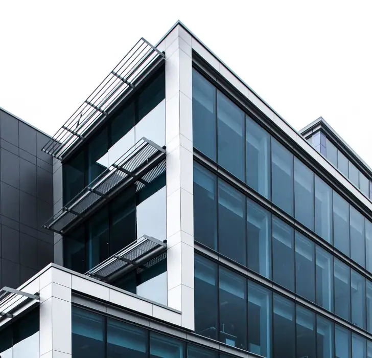 a large glass fronted commercial building taken close up looking up.