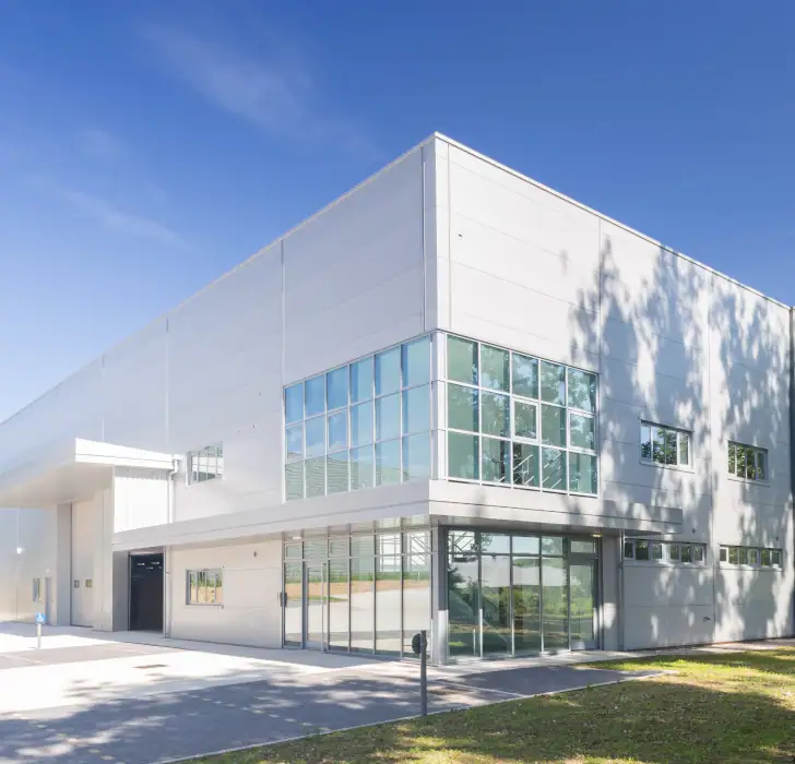 a white commercial building with large windows in the bright sunshine.